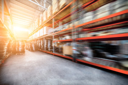 Warehouse industrial and logistics companies. The boxes on high shelves stocked. Motion blur effect. Bright sunlight.